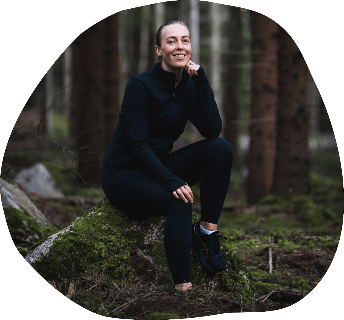 clara sitter i skogen på en sten